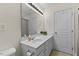 Well-lit bathroom featuring a white vanity, framed mirror and white door to the right of the vanity at 7613 Satinwing Ln, Raleigh, NC 27617