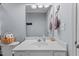 Light blue bathroom featuring a white vanity, framed mirror and a basket of toiletries on the back of the toilet at 7613 Satinwing Ln, Raleigh, NC 27617