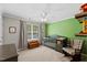 Bedroom featuring an accent wall, wood floors and gray-toned baby furniture at 7613 Satinwing Ln, Raleigh, NC 27617
