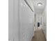 Hallway with a closet featuring paneled doors and neutral-colored walls at 7613 Satinwing Ln, Raleigh, NC 27617