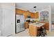 Open kitchen featuring stainless appliances, wooden cabinetry, and a central island with seating at 7613 Satinwing Ln, Raleigh, NC 27617