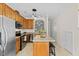 Bright kitchen featuring stainless steel appliances, wooden cabinetry, and a central island with seating at 7613 Satinwing Ln, Raleigh, NC 27617