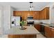 Traditional kitchen with stainless appliances, wood cabinetry, and a large island with space for seating at 7613 Satinwing Ln, Raleigh, NC 27617
