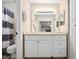 Bathroom vanity with a large mirror, modern lighting, and cabinetry at 7707 Falcon Rest Cir, Raleigh, NC 27615