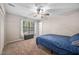 This bedroom has a ceiling fan, carpet and a window with blinds and curtains at 7707 Falcon Rest Cir, Raleigh, NC 27615
