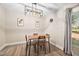 Dining room featuring a modern chandelier, wood table with four chairs, and a view of the outdoors at 7707 Falcon Rest Cir, Raleigh, NC 27615