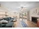 Open living room with hardwood floors, fireplace, ceiling fan, and access to outdoor space at 7707 Falcon Rest Cir, Raleigh, NC 27615