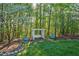 Cozy backyard seating area with a swing under a tree and surrounded by trees at 8309 Nantahala Dr, Raleigh, NC 27612