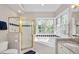 This bathroom features a large tub with windows and tiled shower with gold trim at 8309 Nantahala Dr, Raleigh, NC 27612