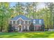 Charming two-story brick home with lush lawn, blue shutters, and mature trees at 8309 Nantahala Dr, Raleigh, NC 27612