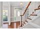 Bright foyer with hardwood floors, white door and staircase with wood handrail at 8309 Nantahala Dr, Raleigh, NC 27612