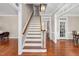 Inviting foyer with hardwood floors and elegant staircase with white risers at 8309 Nantahala Dr, Raleigh, NC 27612