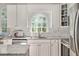 Bright kitchen features white cabinets, granite counters, and large arched window overlooking backyard at 8309 Nantahala Dr, Raleigh, NC 27612
