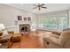 Cozy living room featuring a brick fireplace and large windows overlooking the backyard at 8309 Nantahala Dr, Raleigh, NC 27612