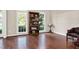 Bright living room with hardwood floors, large windows, and bookcase at 8309 Nantahala Dr, Raleigh, NC 27612