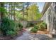 Landscaped backyard with a wooden fence, small bushes, and a stone path alongside the house at 837 Varina Ln, Fuquay Varina, NC 27526