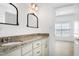 Bathroom with granite countertop vanity, dual sinks, and vintage mirrors at 837 Varina Ln, Fuquay Varina, NC 27526
