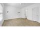 Spacious bedroom with light wood flooring and white walls, adjacent to an open door at 837 Varina Ln, Fuquay Varina, NC 27526