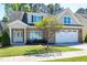 Well-maintained brick home featuring a two-car garage, manicured lawn, and mature tree at 837 Varina Ln, Fuquay Varina, NC 27526