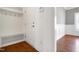 Mud room features built-in bench with hooks, a white interior door, and beautiful wood flooring at 837 Varina Ln, Fuquay Varina, NC 27526