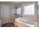 Bathroom with a glass-enclosed shower, jetted tub, and a window for natural light at 906 Ingram Ct, Hillsborough, NC 27278