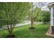 Lush backyard with mature trees, a swing, and a classic white picket fence at 9225 Palm Bay Cir, Raleigh, NC 27617