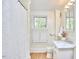 Bright bathroom featuring a marble countertop, white cabinets, and a window with shuttered blinds at 1005 W Lenoir St, Raleigh, NC 27603