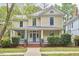 Charming two-story home featuring a welcoming front porch and well-manicured landscaping at 1005 W Lenoir St, Raleigh, NC 27603
