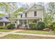 Inviting two-story home with a classic front porch and lush greenery enhancing curb appeal at 1005 W Lenoir St, Raleigh, NC 27603