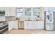 Bright kitchen featuring stainless appliances, white cabinets and light granite countertops, along with hardwood floors at 1005 W Lenoir St, Raleigh, NC 27603
