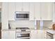 A stylish kitchen with stainless appliances, white cabinetry, and granite countertops, along with hardwood floors at 1005 W Lenoir St, Raleigh, NC 27603