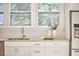 A bright kitchen featuring a stainless sink with white cabinetry and light granite countertops, along with hardwood floors at 1005 W Lenoir St, Raleigh, NC 27603