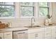 A bright kitchen featuring a stainless sink with white cabinetry and light granite countertops, along with hardwood floors at 1005 W Lenoir St, Raleigh, NC 27603