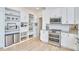 A stylish kitchen with stainless appliances, white cabinetry, and granite countertops, along with hardwood floors at 1005 W Lenoir St, Raleigh, NC 27603