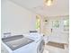 Bright laundry room features modern washer and dryer, window, and storage bench at 1005 W Lenoir St, Raleigh, NC 27603