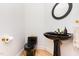 Stylish powder room featuring a unique black toilet and sink with elegant gold fixtures and a decorative mirror at 1011 Wood Sage Dr, Chapel Hill, NC 27516