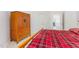 Bright bedroom featuring a cozy red plaid bedspread and wooden wardrobe at 1011 Wood Sage Dr, Chapel Hill, NC 27516