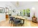 Modern dining room featuring a wooden table, stylish chairs, and large windows overlooking the yard at 1011 Wood Sage Dr, Chapel Hill, NC 27516