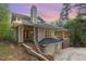 Striking home with a chimney and attached two car garage at dusk at 1011 Wood Sage Dr, Chapel Hill, NC 27516
