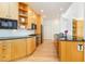 Kitchen boasts modern wood cabinets, black appliances and countertops, and hardwood floors at 1011 Wood Sage Dr, Chapel Hill, NC 27516