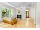 Cozy living room featuring hardwood floors, fireplace, and large windows with natural light at 1011 Wood Sage Dr, Chapel Hill, NC 27516