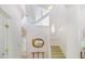 Bright foyer with high ceilings showcasing a decorative mirror, open staircase, and modern light fixtures at 1011 Wood Sage Dr, Chapel Hill, NC 27516
