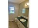 Bathroom featuring a green countertop vanity, neutral flooring, and natural light from a window at 1031 Jackson Royster Rd, Henderson, NC 27537