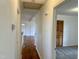 Hallway with hardwood floors transitions into a bedroom with neutral carpet, offering a seamless flow throughout at 1031 Jackson Royster Rd, Henderson, NC 27537