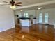 Spacious living room with hardwood floors, a ceiling fan, and an open view to the adjacent kitchen area at 1031 Jackson Royster Rd, Henderson, NC 27537