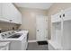 Functional laundry room equipped with modern appliances, storage cabinets, and a convenient mud bench at 109 Deer Valley Dr, Cary, NC 27519