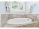 Bathroom showcasing an oval soaking tub with tiled surround and chrome faucet at 1101 Sky Wave Trl, Raleigh, NC 27603