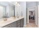 Bathroom with double sink vanity, grey cabinets, and a door to the walk-in closet at 1101 Sky Wave Trl, Raleigh, NC 27603