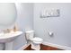 Powder room with pedestal sink, decorative mirror, and a painting with a sailboat theme at 1101 Sky Wave Trl, Raleigh, NC 27603
