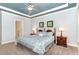 Bedroom with large bed, matching nightstands, and a ceiling fan with blue tray ceiling at 1101 Sky Wave Trl, Raleigh, NC 27603